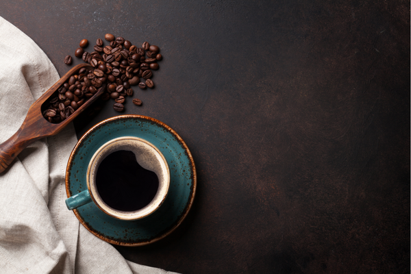 Kaffeebohnen und frischer Kaffer in einer türkisen Tasse